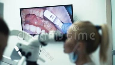 牙医与助理一起工作，带<strong>口腔</strong>摄像机和监视器，看眼睛